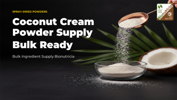 Coconut cream powder cascading from rose gold scoop into glass bowl with coconut and palm leaf accent