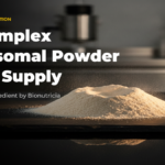 Liposomal B complex powder shown as an ivory to pale golden mound on dark polished stone